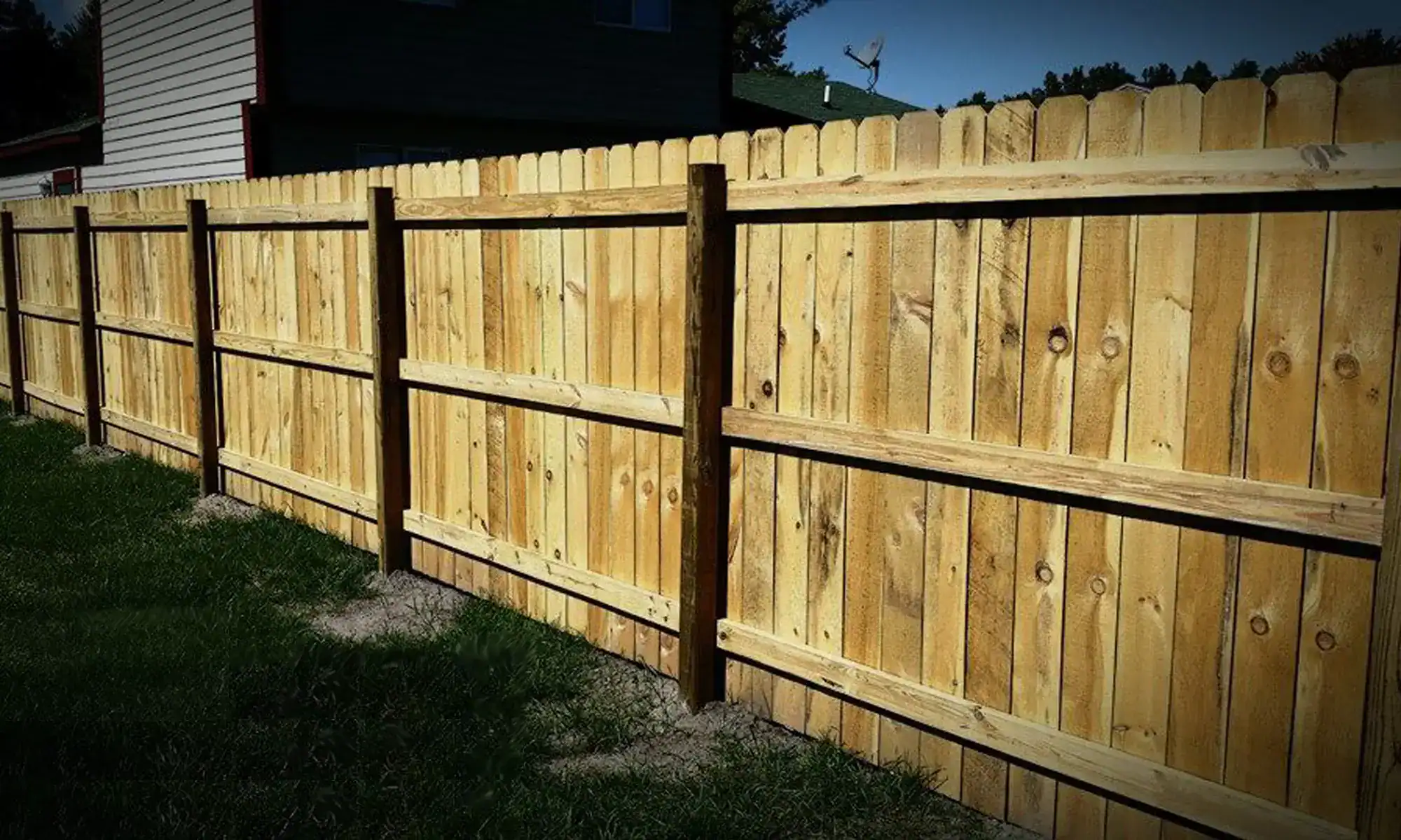 Solid board wood privacy fence running along a back property line, installed by Future Solutions Fence