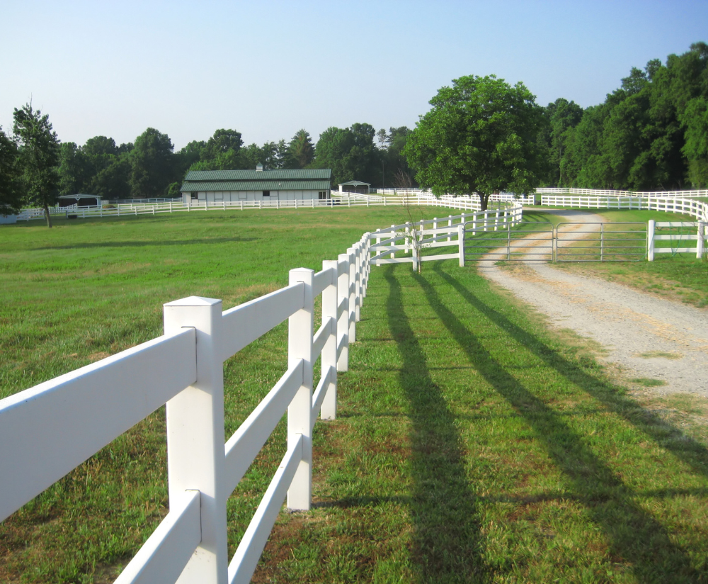 White vinyl farm fence leading onto the farm