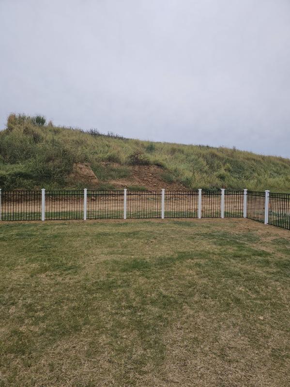 Black aluminum fence racked down a sloping bank, installed by Future Solutions Fence