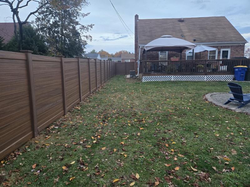 Woodgrain vinyl privacy fence along a rear boundary, installed by Future Solutions Fence