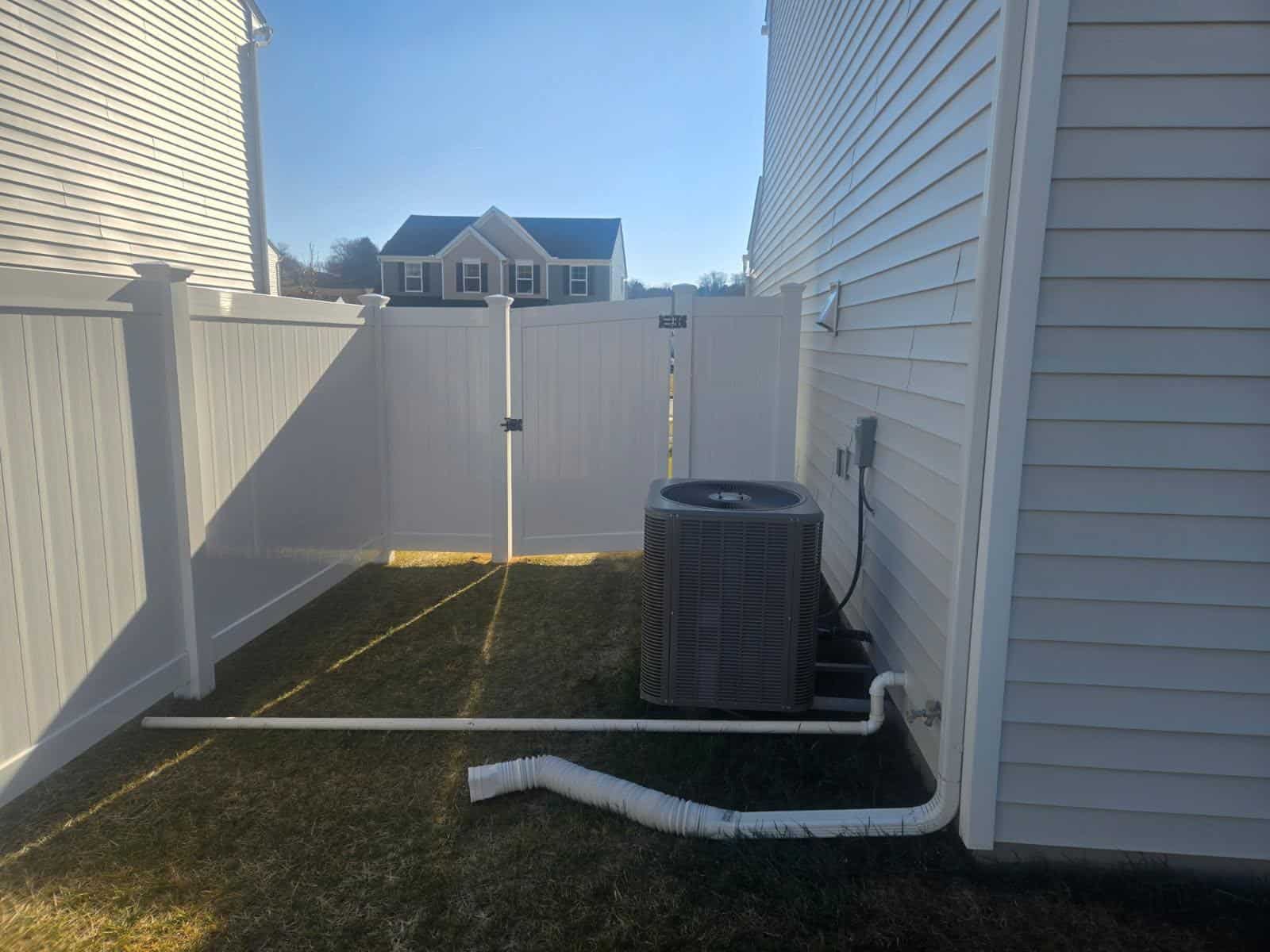 White vinyl privacy fence closing off a narrow side yard beside a house, installed by Future Solutions Fence