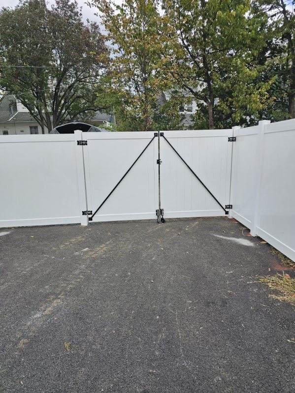 White vinyl privacy double gate with a drop rod across a driveway, installed by Future Solutions Fence