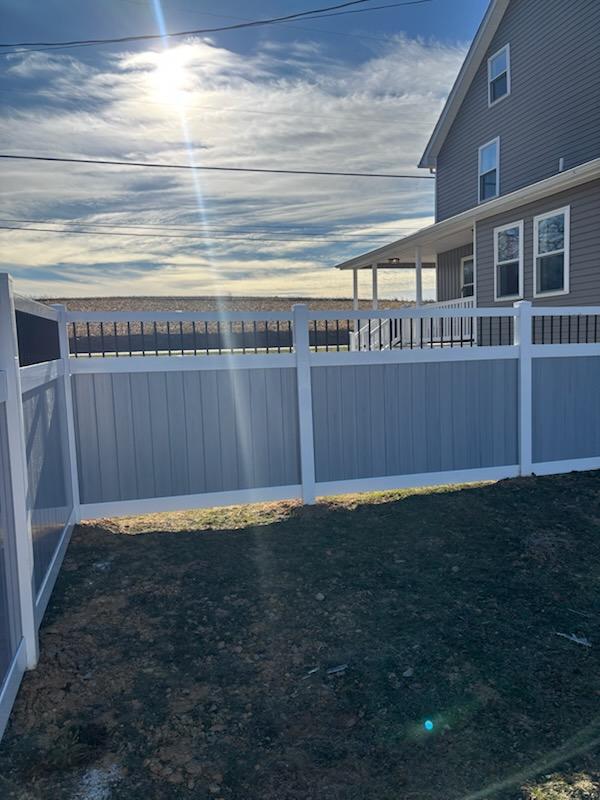White vinyl privacy fence with an open top section beside a house, installed by Future Solutions Fence
