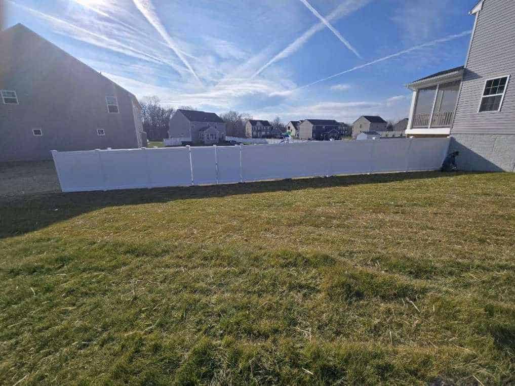 White vinyl privacy fence enclosing a suburban back lawn, installed by Future Solutions Fence